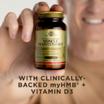 A man smiling holding an amber glass bottle of Solgar Muscle Maintenance in his fingertips. Text on image reads, "With clinically-backed myHMB + Vitamin D3"