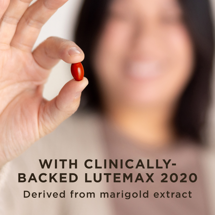 A woman smiling holding one red softgel capsule of Solgar Digital Defense in her fingertips. Text on image reads, "With clinically-backed Lutemax-2020, derived from marigold extract"